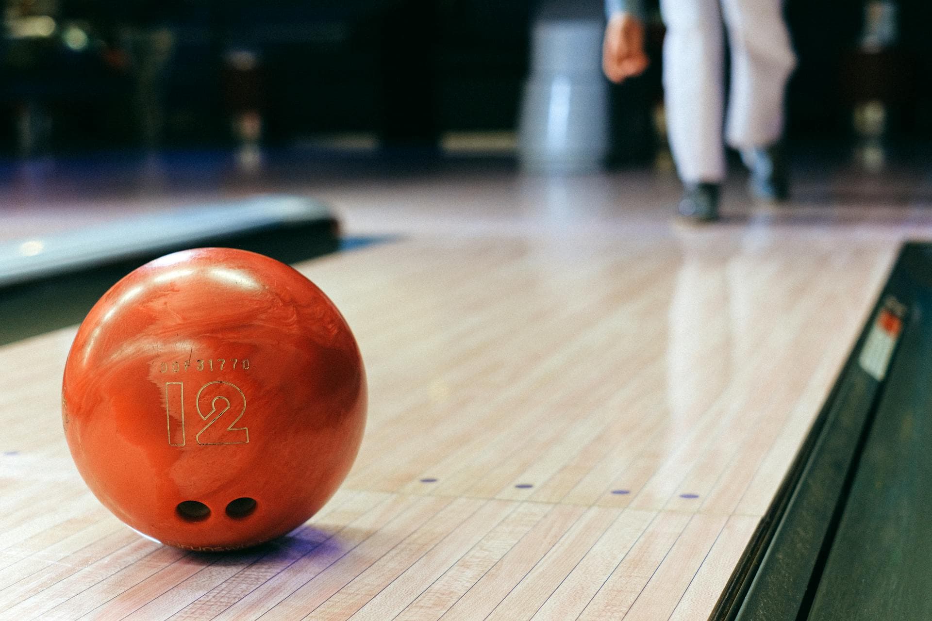 Red bowling ball on a polished lane