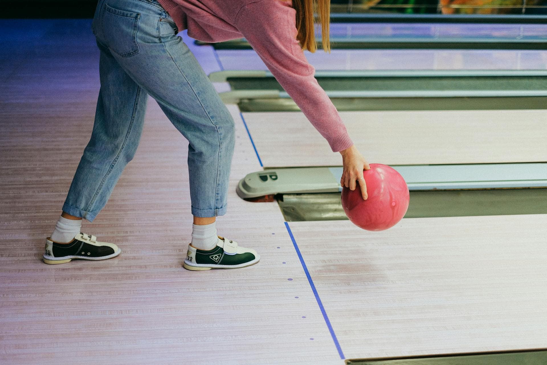 Bowler releasing a pink ball down the lane